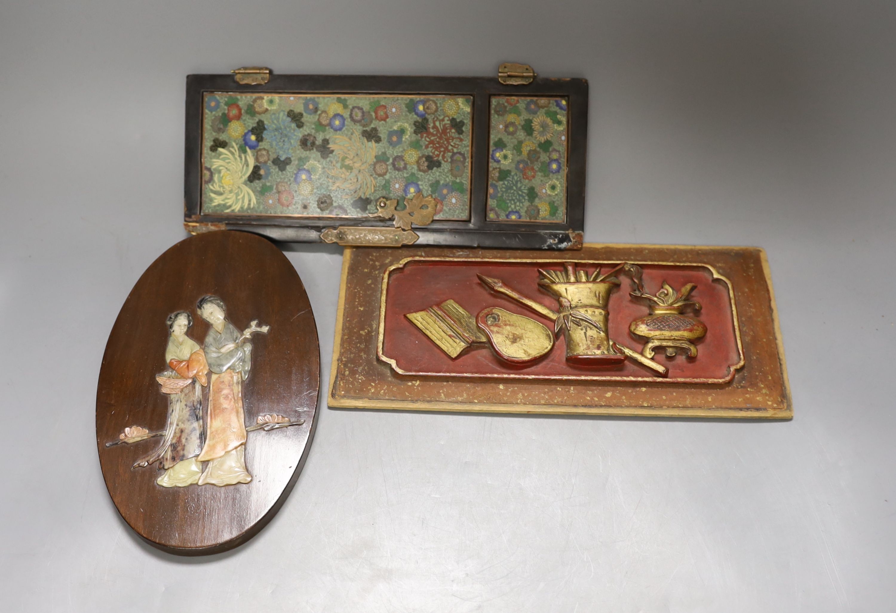 A Japanese Cloisonné enamel panelled cabinet door, 25.5 cm high, a Chinese lacquered wood panel, 26.5 X 12 cm and a Chinese soapstone in laid hardwood panel depicting two ladies, 20 cm high